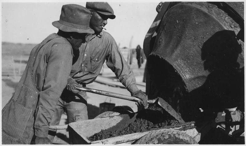 File:Oglala Dam, two men load wheelbarrow with concrete from the mixer - NARA - 285474.tif