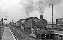 GWR 5101 Class No.4121 piloting No.4998 Eyton Hall on a mixed freight train through Pilning, having climbed the bank up from the Severn Tunnel, 1961 Pilning High Level station up freight geograph-2935954-by-Ben-Brooksbank.jpg