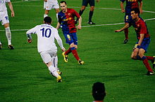 Rooney takes on Andres Iniesta and Sergio Busquets of Barcelona during the 2009 UEFA Champions League Final Rooney defended by Iniesta, Busquets, UEFA Champions League Final 2009.jpg