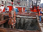 Sheet piling activities with a heavy trembling block in the wet grounds under the street Rokin in Amsterdam city; free photo of Fons Heijnsbroek, 2007