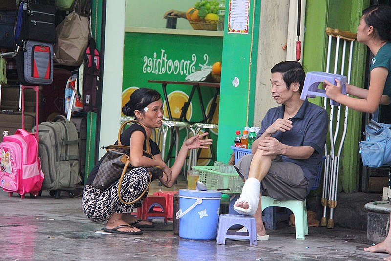 File:Squatting smoking female sitting man Hanoi Vietnam.jpg