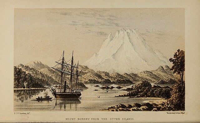 A white mountain rising over a forested bay with a ship