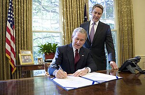 With Sen. Bill Frist (R-TN) looking on, President George W. Bush signs into law Pub. L.Tooltip Public Law (United States) 109-353 (text) (PDF), the North Korea Nonproliferation Act of 2006, on October 13, 2006. With Sen. Bill Frist (R-Tenn.) looking on, President George W. Bush signs into law S-3728, the North Korea Nonproliferation Act of 2006, Friday, Oct. 13, 2006, in the Oval Office.jpg