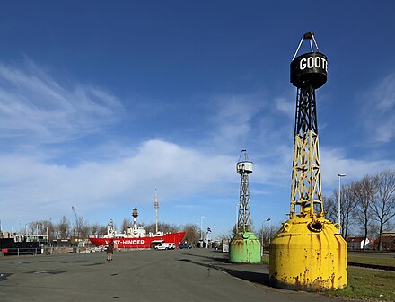 The marina of Zeebrugge, which is littered with maritime items, like these two beacons and the West-Hinder II in the background.