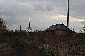 Видна грунтовая дорога и домохозяйство, столбы для электропроводов