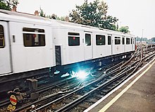 Electricity arcs between the power rail and electrical pickup "shoe" on a London Underground train Arcing pickup shoe.jpg