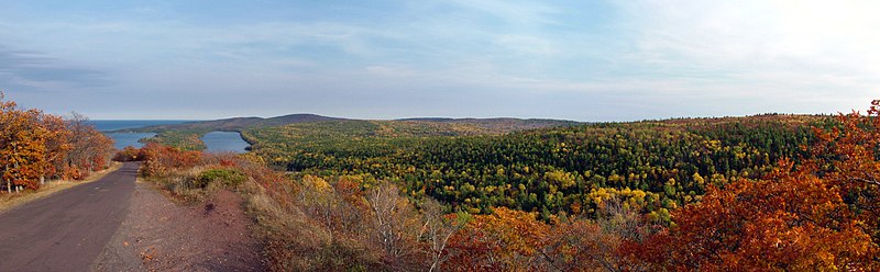 Aŭtuna panoramo de la pinto de Brockway Monto kun Lago Fanny Hooe kaj Supra Lago en la distanco kaj Brockway Mountain Drive descendanta la monteto