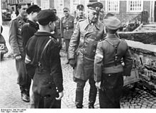 German field marshal Walter Model in october 1944 expresses his appreciation to a Hitler Youth leader for the entrenchment work carried out by the young men.
Photo: Bundesarchiv Bundesarchiv Bild 183-J28036, Deutschland, Model bei Hitlerjugend.jpg