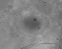 A high-resolution New Horizons image of a section of Burney and its interior craters. One of Burney's rings form a chain of mountains that arcs across the image. Scale bar of 6 mi (9.7 km) is at the top left