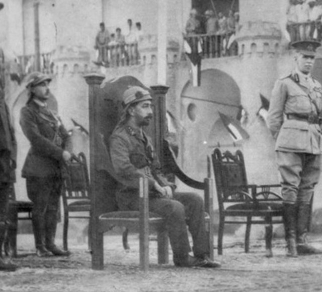 Coronation of Faisal as King of Iraq. Faisal seated, to his right are British High commissioner Percy Cox and Lieutenant Kinahan Cornwallis, to his le