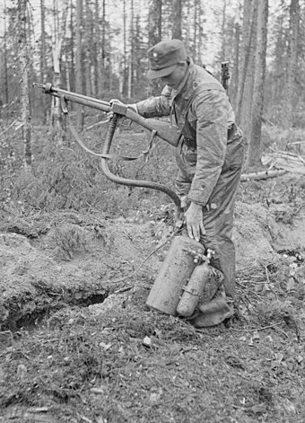 A Finnish soldier with a captured Soviet ROKS-3 flamethrower, June 1943. Note the flame projector has been designed to resemble a standard infantry rifle.