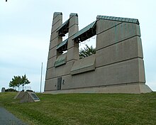 Tall, oddly-shaped concrete structure with bells