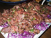 Limu poke (Poke with a type of seaweed), prepared with fresh ahi (yellowfin tuna), inamona (chopped kukui nuts), green onions, and long ogo (a kind of limu or seaweed that branches like small blood vessels and tastes like the ocean) served on red cabbage