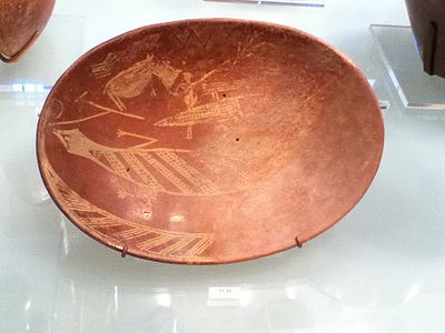 A plate created during the Early Dynastic period of Ancient Egypt.  It depicts a man on a boat alongside a hippopotamus and a crocodile