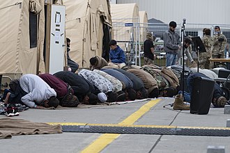 Afghan evacuees bow (Sujud) during noon (Zuhr) congregational prayer (Salah al jama'ah) at Ramstein Air Base in Germany, 27 August 2021 Ramstein supports evacuees religious needs.jpg