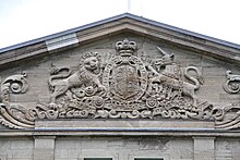 The royal coat of arms of the United Kingdom carved into the tympanum of the pediment atop the Mappin block in 1914, seven years before the creation of the Royal Coat of Arms of Canada. Evidence of the 2006-2007 restoration can be seen in the mismatched colouration of the stones in the hood mould. Rideau Hall 30.jpg