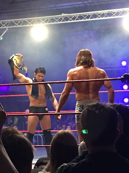 Shibata (left) defending the British Heavyweight Championship against Matt Riddle in January 2017