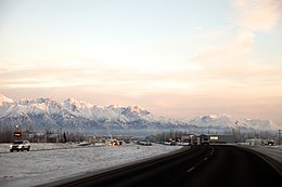 Southbound George Parks Highway approaching the Trunk Road interchange. The Chugach Mountains and Mat-Su Regional Medical Center are in the background.