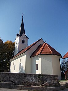 Image of a small church with white walls, a red roof, and a thin black steeple.