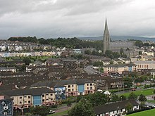 A view of Derry looking towards St Eugene's Cathedral, the mother church of the Roman Catholic diocese of Derry, across the Bogside's Lackey Road and Fahan Street, taken from the Grand Parade on the City Walls. Houses are visible, two have a mural