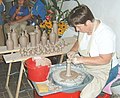 A woman making pottery.
