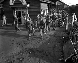 Soldaten dragen hun koffers van een trein in een Koreaans treinstation