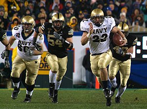 Fullback Adam Ballard (22) rushes while being pursued by defenders Cason Shrode (54) and Taylor Justice (42) during the 2005 Army-Navy Game, a college football rivalry in the United States US Navy 051203-N-2383B-223 U.S. Naval Academy Midshipman fullback Adam Ballard (22) rushes for one of two touchdowns while being persued by Army defenders Cason Shrode (54) and Taylor Justice (42).jpg