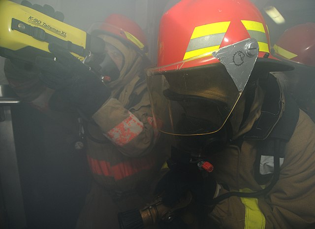 Gulf of Oman, (15 December 2011). A firefighting team enters a smoke-filled room to extinguish a mock fire during a general quarters drill aboard Bata