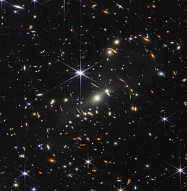 Инфракрасное изображение Космического телескопа Джеймса Уэбба. Первое глубокое поле Уэбба, показывающее гравитационное линзирование далеких галактик.