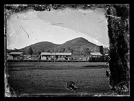 Boppy Mount railway station c.1910, with the landform, Mount Boppy, in the background. The water tower is visible on the right. Boppy Mount Canbelego east of Cobar NSW - gold mining 1901-1923.jpg