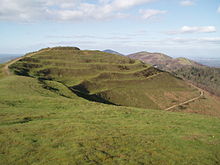 Photo of the British Camp hill showing its terraced Iron Age earthworks