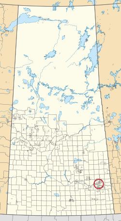 Mapa provincie Saskatchewan zobrazující 297 venkovských obcí a stovky malých indických rezerv. Jeden je zvýrazněn červeným kruhem.