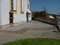 Die Lage des Hallenbaus (Aula) wird an der Kirche von Kellmünz durch die braune Pflasterung markiert