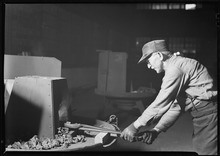 Blacksmith using tongs Eddystone, Pennsylvania - Railroad parts. Baldwin Locomotive Works. Blacksmith forging and hammering tools. - NARA - 518729.tif