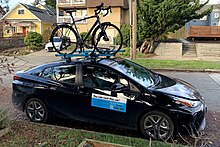 GIG Car Share 2020 Toyota Prius XLE parked with a bicycle on its roof rack in Seattle GIG Car Share car carrying a bicycle.jpg