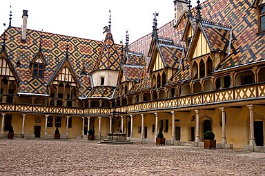 Cour intérieure des Hospices de Beaune et ses toits de tuiles vernissées caractéristiques de la Bourgogne.