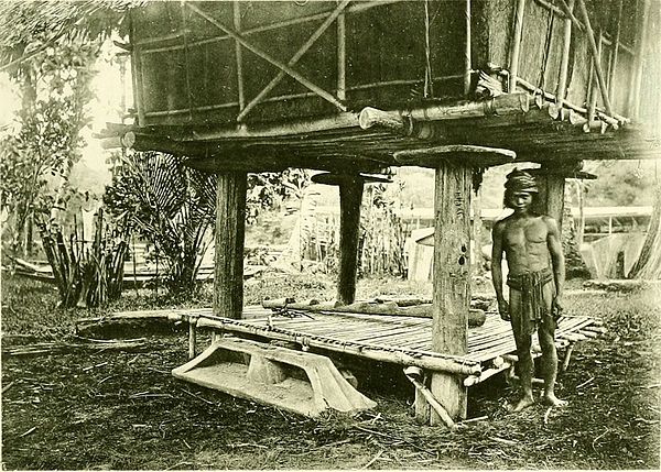 A Kedayan man, standing underneath a rice barn.