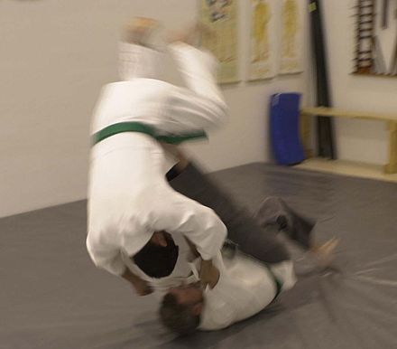 A tomoenage front sacrifice throw used against a front-pushing attacker