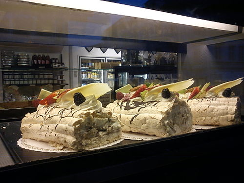 Three Fragelité cakes on display in a bakery in Denmark. Fragelité is a Danish specialty. The image holds more information.