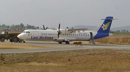 A Lao Airlines ATR-72 at Xiang Khouang Airport. Note the cow on the apron.