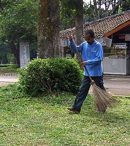 Petugas kebersihan sedang menyapu di Ragunan, Jakarta, Indonésia