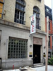 A manhattan building with a flag outside labeled NYPSI New York Psychoanalytic Society and Institute