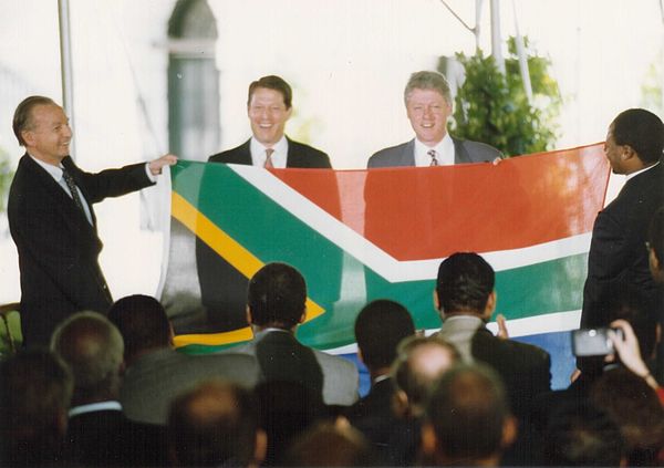 South African Ambassador to the U.S. Harry Schwarz presenting the new flag to the U.S. president Bill Clinton and vice president Al Gore in May 1994.