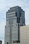 Földszintes kilátás egy díszes épületre, váltakozó beton és kék színű üveghomlokzatokkal.  Az épület tetővonala közelében az "ÁLLAMI UTCA" feliratú tábla látható.  Az épület lezárása koronaszerű szerkezet, amely kék üvegből és fehér tornyokból áll.