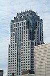 Vista al piano terra di un edificio decorato con facciate alternate in cemento e vetro colorato di blu.  Vicino alla linea del tetto dell'edificio è visibile un cartello con la scritta "STATE STREET".  A coronare l'edificio c'è una struttura a forma di corona composta da vetro blu e guglie bianche.