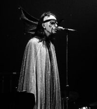 Gabriel in 1974 performing "Watcher of the Skies", dressed in a cape with bat wings and fluorescent makeup Peter Gabriel The Watcher of the Skies (cropped).png