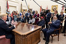West (red cap) in the Oval Office on October 11, 2018 President Donald Trump and Kanye West 2018-10-11.jpg
