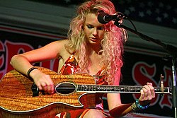 Taylor Swift tocando em uma cafeteria com um violão de acácia, em junho de 2006.