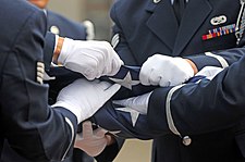 Members of the 86th Airlift Wing honor guard conduct a flag-folding ceremony at Ramstein Air Base, Germany, 2009. USAF Honor Guard flag folding.jpg