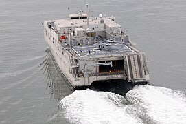 USNS Spearhead (T-EPF-1), an expeditionary fast transport and the lead ship of her class. This is a rear view, showing a MH-60S Seahawk helicopter on the helideck